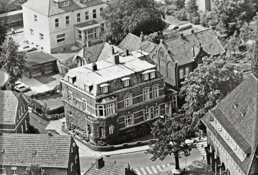 Historische Luftaufnahme der Krupp'schen Villa in Meppen, ehemaliger Sitz der Emsland GmbH, umgeben von Nachbargebäuden.