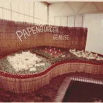 Ausstellungsstand der Papenburger Gemüsegenossenschaft mit Modell, Tomatenrand und Schriftzug 'Papenburger Gemüse' auf Bambushintergrund.