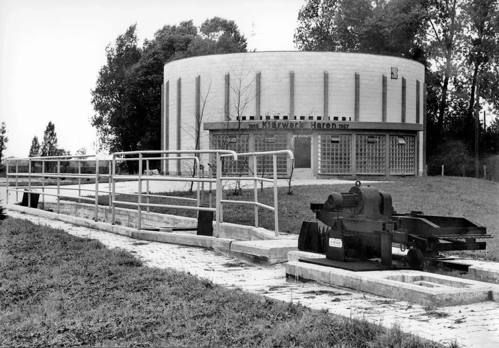 Schwarzweißfoto des Klärwerks Haren mit rundem Betonbau, Beschriftung 1966–1967 und technischen Anlagen im Vordergrund.