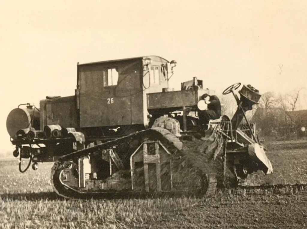 Historisches Schwarzweißfoto eines Kettenfahrzeugs mit Nummer 26 beim Kultivierungseinsatz im Emsland, 1950er Jahre.