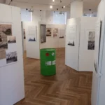 Museumsraum mit historischen Tafeln und grünem Ölfass als Ausstellungsobjekt zur Geschichte der Lingener Raffinerie.