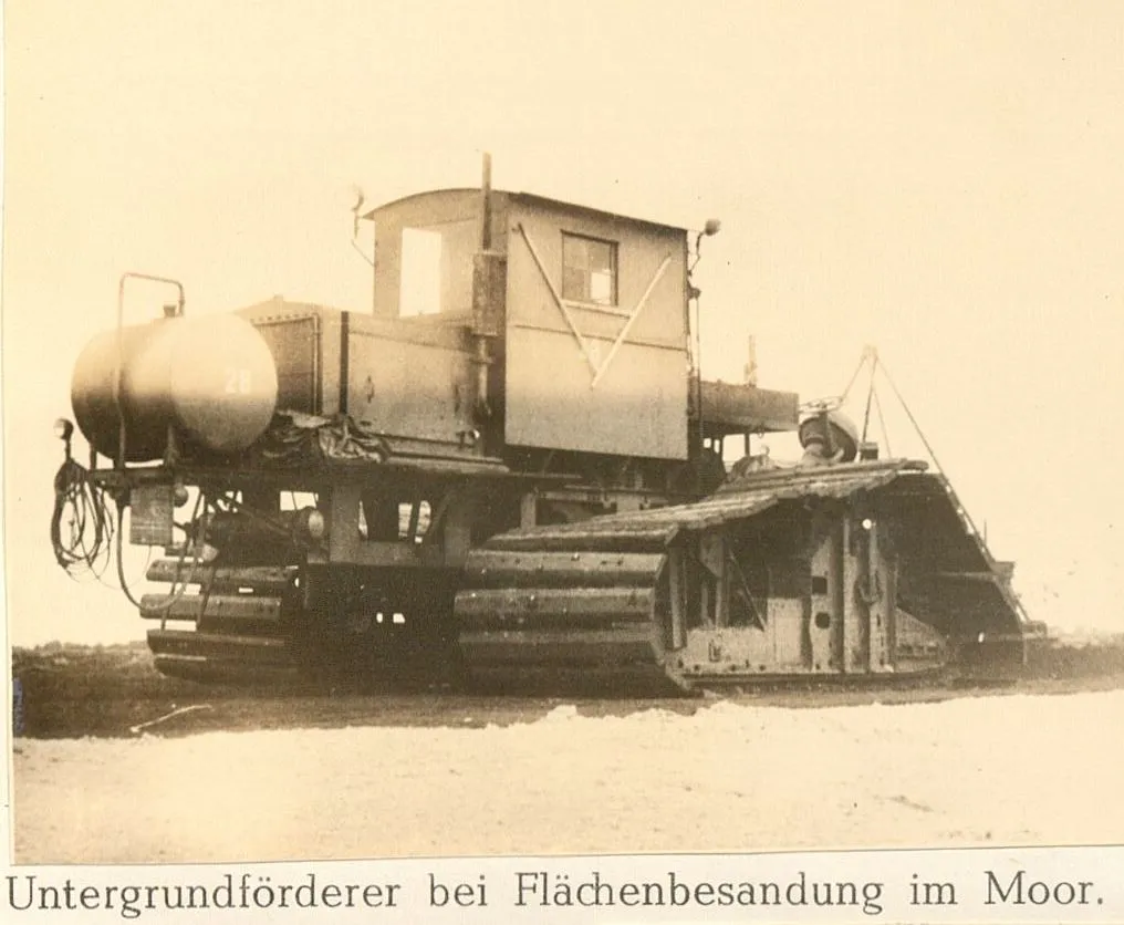 Historische Aufnahme eines Untergrundförderers auf Gleisketten bei der Flächenbesandung im Moor, 1950er-Jahre.