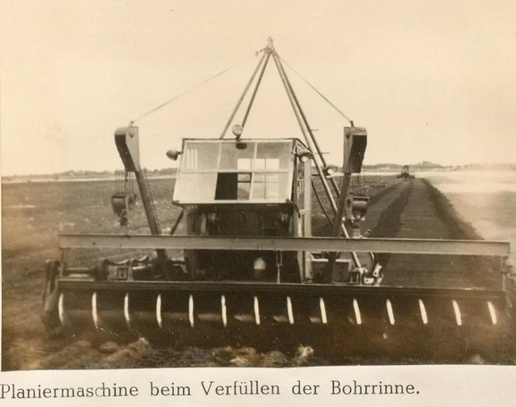 Historische Planiermaschine der Firma Rathjens bei der Kultivierungsarbeit im Emsland, Frontalansicht mit Räumschild.