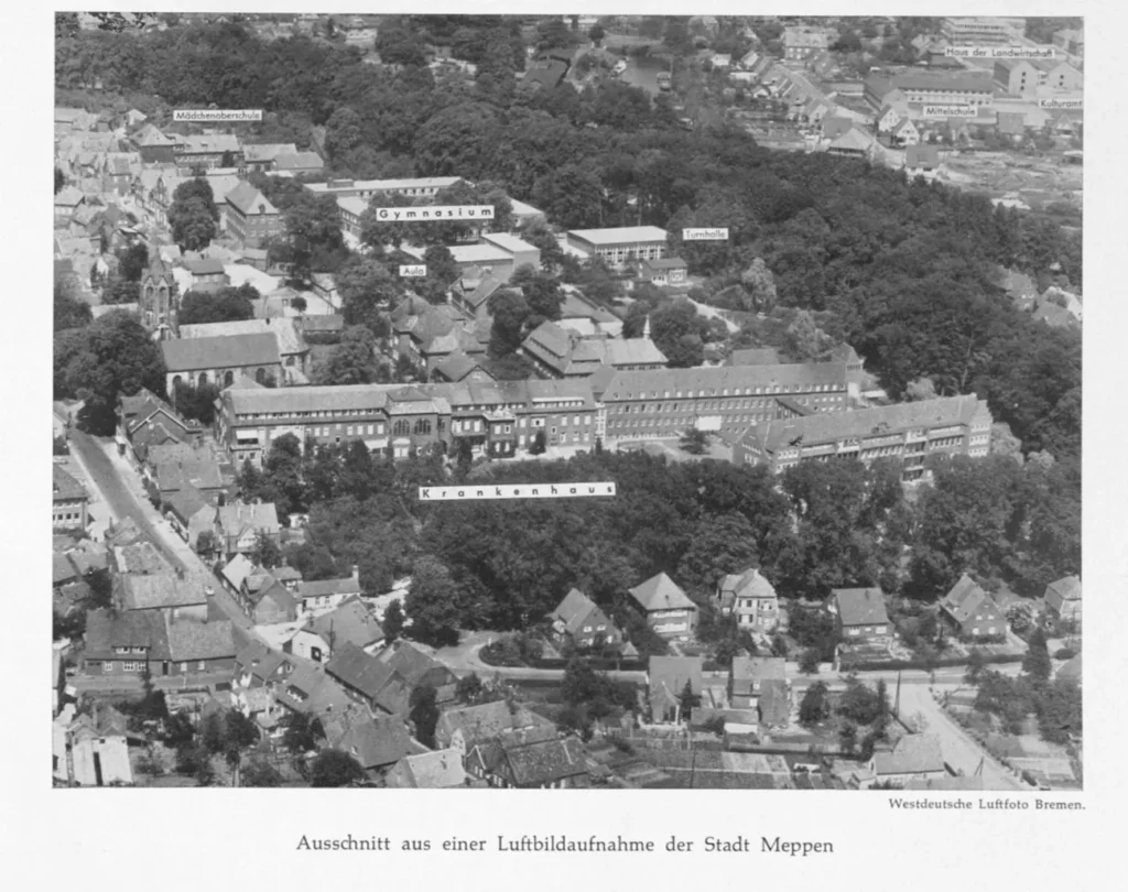 Schwarz-Weiß-Luftaufnahme der Stadt Meppen mit beschrifteten Gebäuden: Gymnasium, Krankenhaus, Mädchenoberschule und Mittelschule.