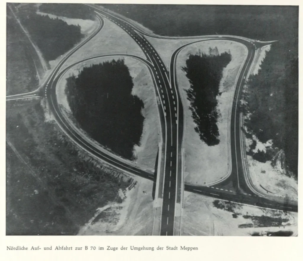 Luftaufnahme des nördlichen Autobahnkreuzes der B70 bei Meppen mit geschwungenen Auf- und Abfahrten inmitten bewaldeter Flächen.