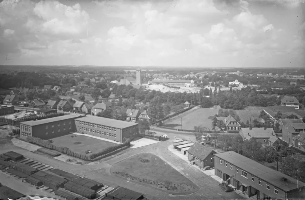 Historische Luftaufnahme von Lingen mit einem großen Industriegebäude der Schachtbau-Gesellschaft inmitten einer Wohnsiedlung.