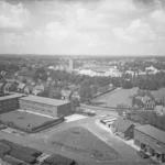 Historische Luftaufnahme von Lingen mit einem großen Industriegebäude der Schachtbau-Gesellschaft inmitten einer Wohnsiedlung.