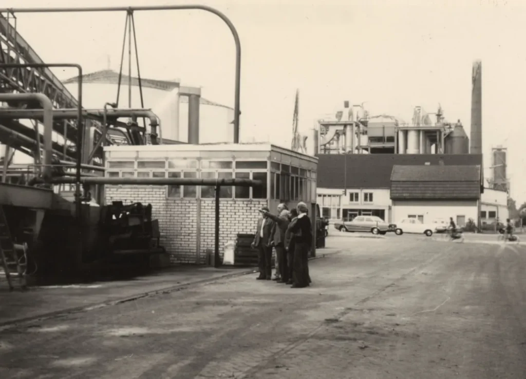 Schwarzweißfoto des Industriegeländes der Emsland-Stärke GmbH mit Arbeitern, Maschinen und Fabrikgebäuden, ca. 1970er Jahre.