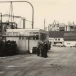 Schwarzweißfoto des Industriegeländes der Emsland-Stärke GmbH mit Arbeitern, Maschinen und Fabrikgebäuden, ca. 1970er Jahre.