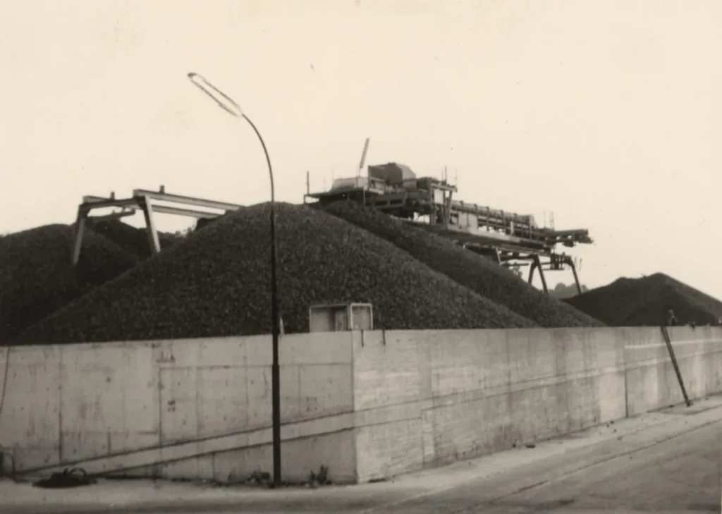Große Kartoffelhaufen hinter einer Betonmauer mit Förderanlagen auf dem Gelände der Emsland-Stärke GmbH.