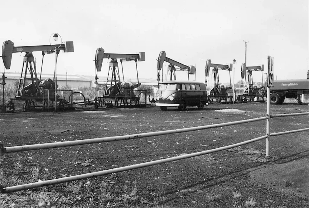 Mehrere Erdölpumpen auf einem Förderfeld im Emsland, im Hintergrund ein VW-Bus und ein Tankwagen.