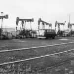 Mehrere Erdölpumpen auf einem Förderfeld im Emsland, im Hintergrund ein VW-Bus und ein Tankwagen.