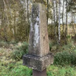 Historischer Betonstein mit Inschrift CGS NAM V im Naturpark Moor, Grenzmarkierung des Erdölkonzerns NAM von 1948.