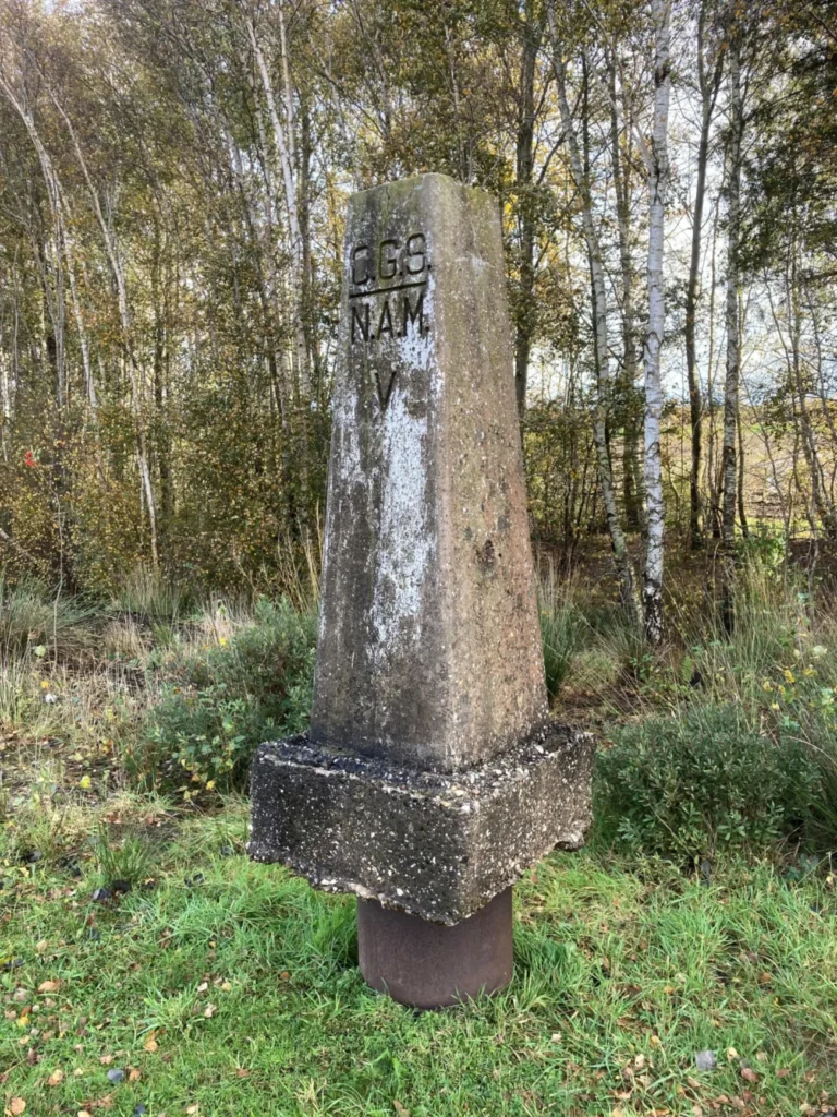Historischer Betonstein mit Inschrift CGS NAM V im Naturpark Moor, Grenzmarkierung des Erdölkonzerns NAM von 1948.