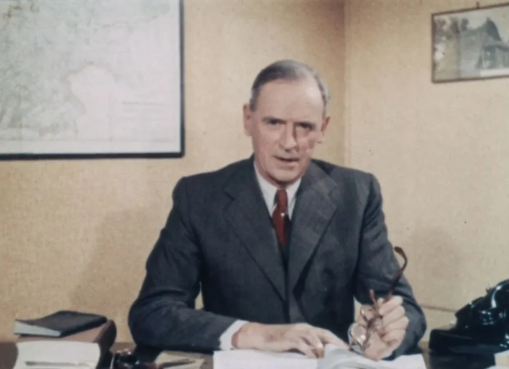 Johann Dietrich Lauenstein, Geschäftsführer der Emsland GmbH, sitzt im Anzug an seinem Büroschreibtisch.