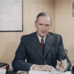 Johann Dietrich Lauenstein, Geschäftsführer der Emsland GmbH, sitzt im Anzug an seinem Büroschreibtisch.