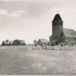 Blick auf die neue Siedlung Hasselbrock mit Backsteinkirche und jungen Bäumen auf unbefestigtem Gelände, um 1950.