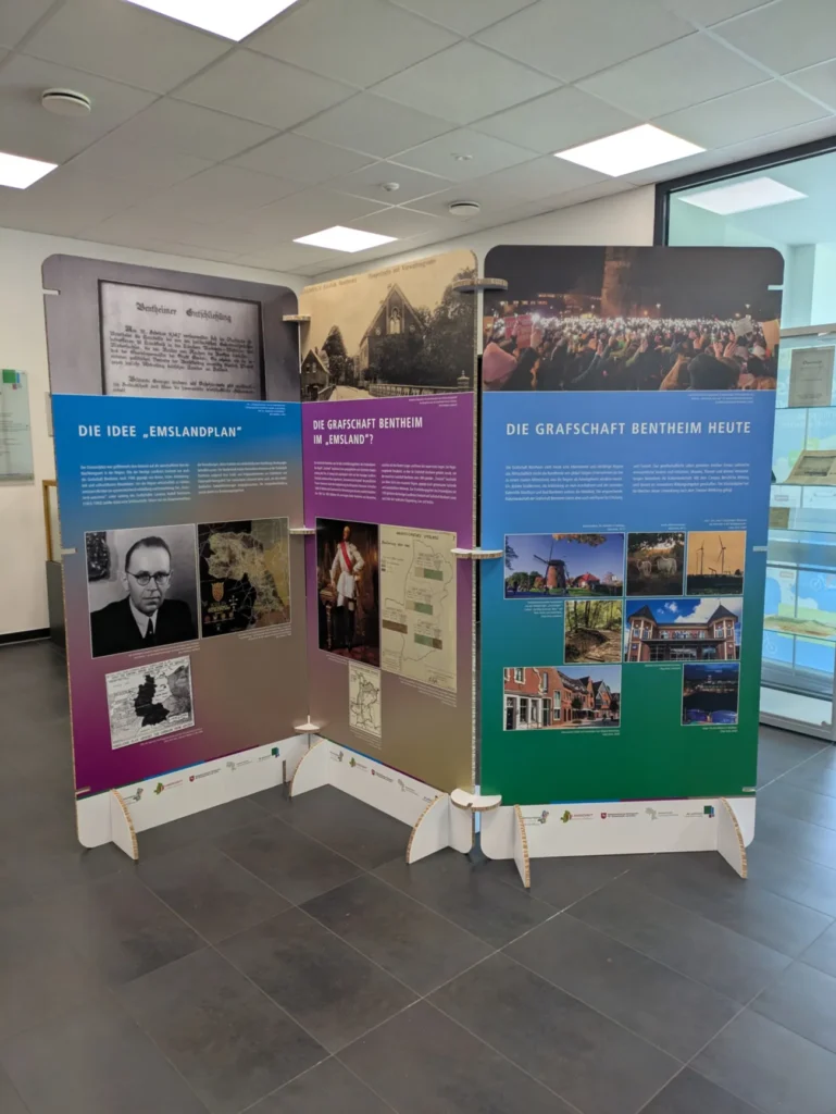 Drei farbige Ausstellungstafeln zur Geschichte der Grafschaft Bentheim und dem Emslandplan in einem modernen Archivgebäude.