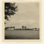 Historische Schwarzweißaufnahme eines Brückenneubaus mit Baugerüst auf einer weiten Feldlandschaft im Emsland.